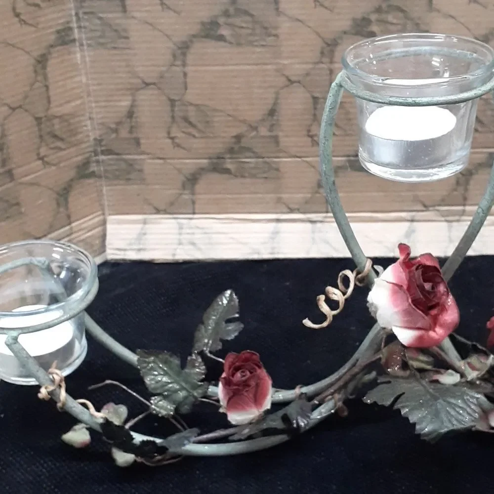 Long 3 candle black iron candle holder laced with trailing red roses.‎